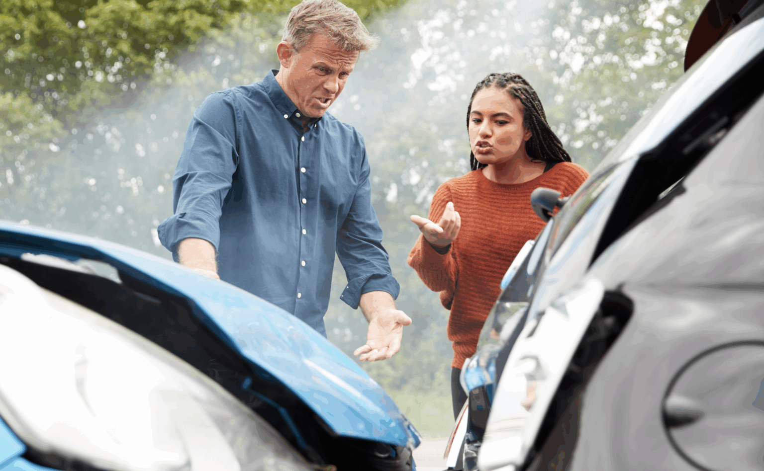 A man and woman arguing in front of the scene of a car accident trying to figure out fault | Daniel Stark Law
